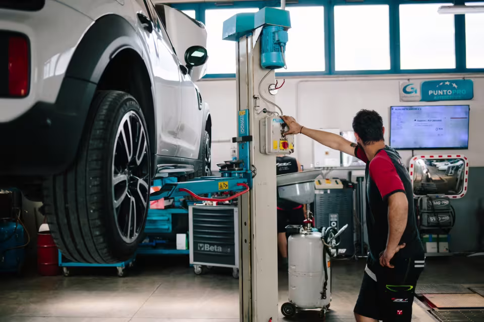 Auto sollevata sul ponte durante un intervento all'officina LR Motorsport di Ponte nelle Alpi